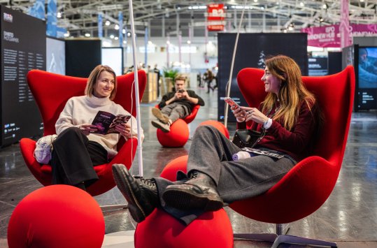 Zwei Frauen sitzen in Sesseln auf der ISPO und networken