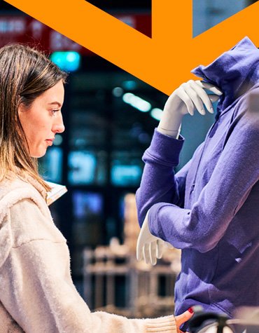 Besucherin betrachtet Jacke in der Award Exhibition Area der ISPO