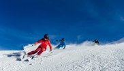 Three skiers ski on the slopes