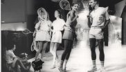 Models führen Tennisbekleidung auf einer Bühne vor.