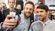Ein Besucher macht ein Selfie mit Michael Phelps.