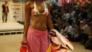 Ein attraktives Model in Strandmode, in der Hand eine Decke und ein Wasserzerstoiber.