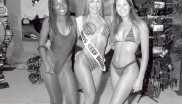 Drei Models in Bademode, die mittlere trägt eine Schärpe mit den Worten "Miss Reef Brazil".