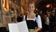 Magdalena Neuner zeigt stolz die Urkunde nach Verleihung des bayerischen Verdienstordens.