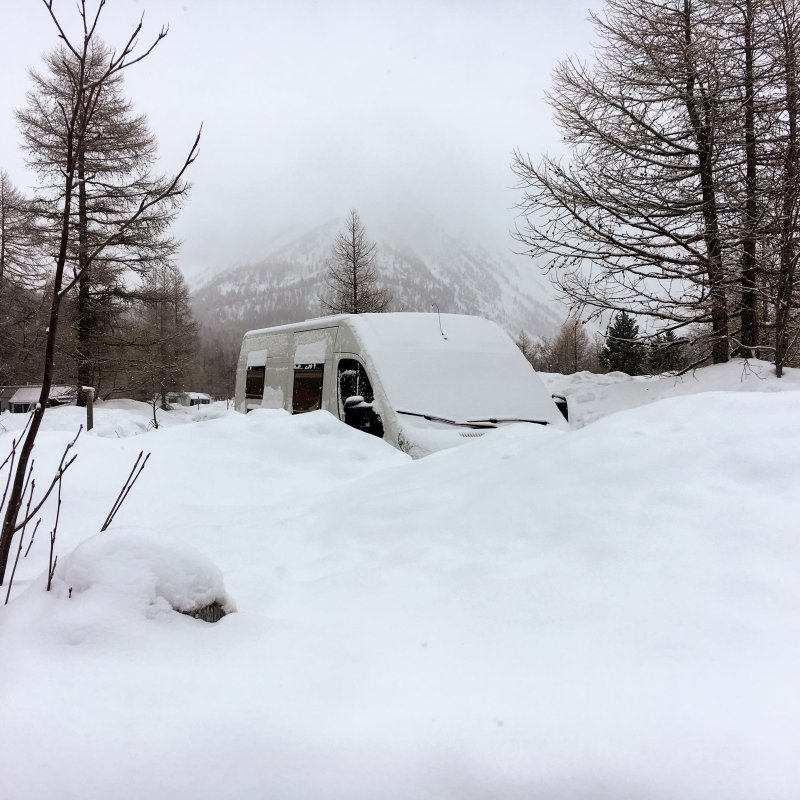 Verschneiter Bus beim Wintercamping