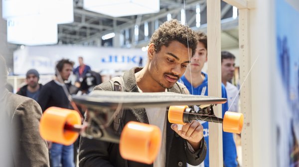 Ein Mann begutachtet ein Skateboard