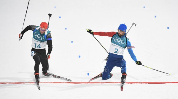 The photo finish decides: Only one foot tip separates Simon Schempp (l.) from the gold medal. At the end of the mass start over 15 kilometres Martin Fourcade is 18 thousandths of a second faster (or 14 centimetres ahead) - and Olympic Champion. 