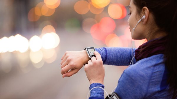 Woman with heart rate monitor and Smartwatch jogging