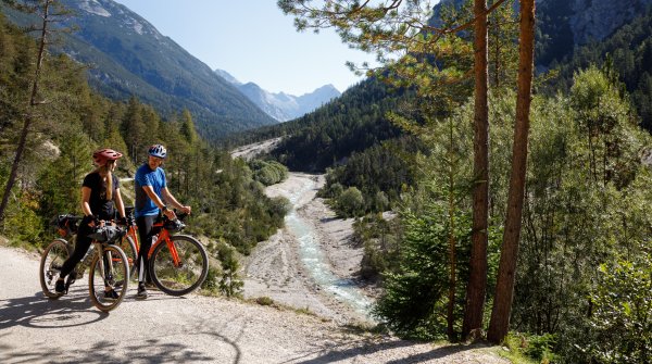 Zwei Fahrradfahrer sind mit dem Gravelbike auf dem Schotter unterwegs