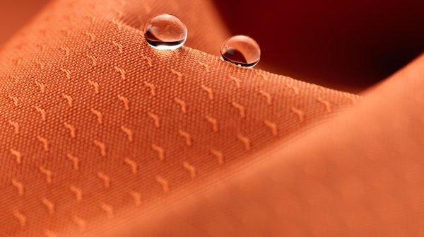 orangefarbiger Stoff mit Struktur, wasserabweisend ausgerüstet