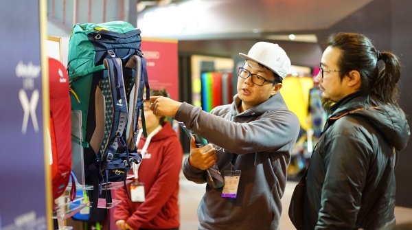 Two men inspect a rucksack.