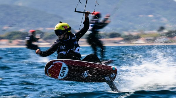 Eine Formula Kite Pilotin fliegt übers Wasser 