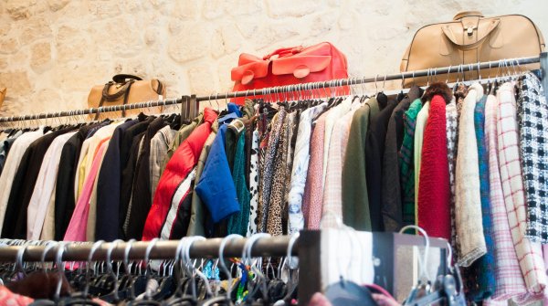 A row of clothes hangs on a clothes rack. 