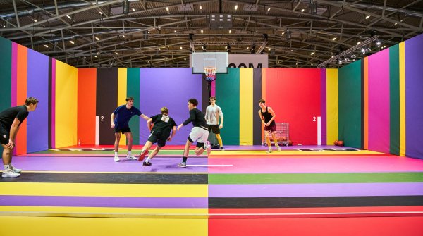 Junge Leute spielen auf buntem Basketballplatz