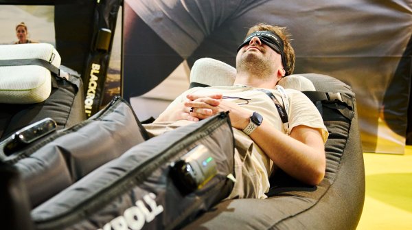 Man lying on a pleasure chair and testing compression boots from Blackroll