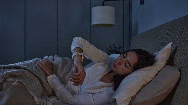 Frau trackt ihren Schlaf im Bett