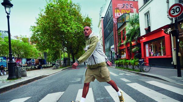 Young man with shorts runs across crosswalk