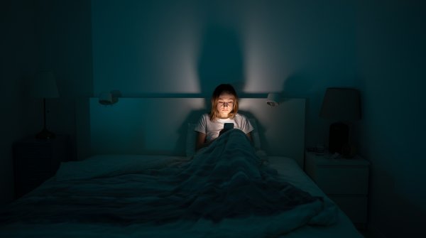 Frau nachts im Bett am Handy