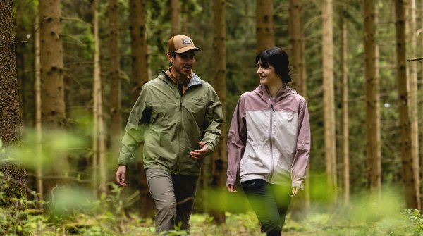Frau und Mann mit Outdoor Jacken von Marmot im Wald