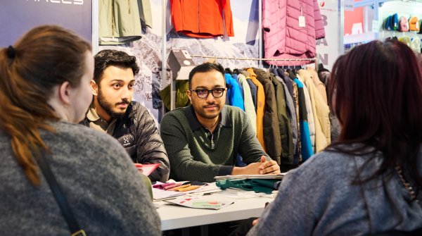 Two retailers and two interested customers discuss outdoor topics at ISPO 2024