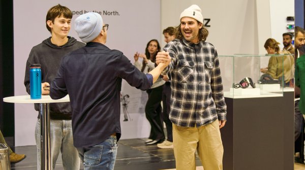 Zwei Männer geben sich auf der Messe die Hand