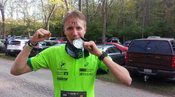 Charles Franzke testet seine Medaille auf Bissfestigkeit