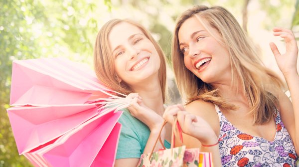 Zwei Frauen schauen glücklich nach einer Shopping-Tour