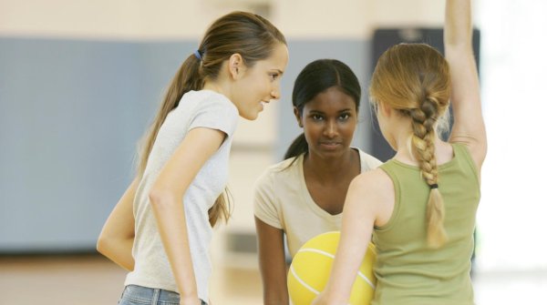 Drei Mädchen spielen mit einem Ball.