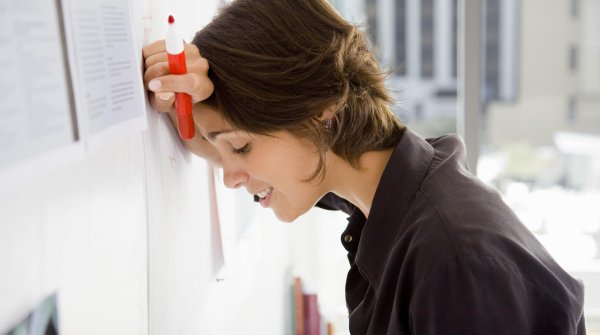 A woman in search of the right remedies for stress leans desperately against the wall