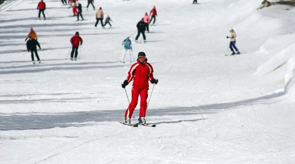 Eine Frau fährt auf Ski einen Hügel hinunter