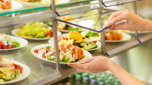 Hand mit Teller in der Kantine