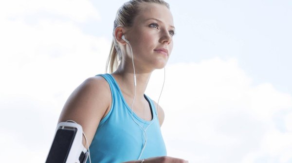 Eine junge Frau joggt mit Smartphone