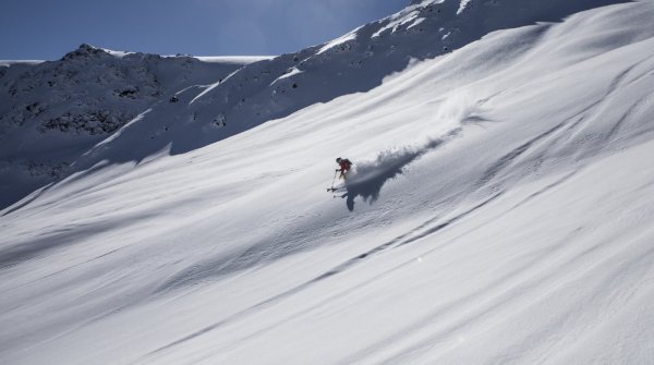 Skifahrer fährt die Piste herab