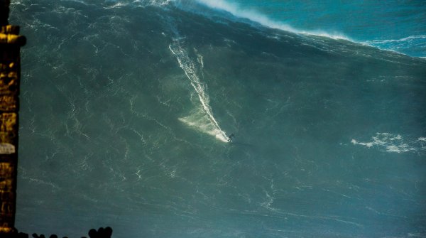 Geht im Bild fast unter: Sebastian Steudtner surft eine Mega-Welle.