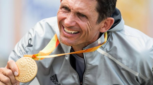 Michael Teuber präsentiert überglücklich seine Goldmedaille von Rio 2016.