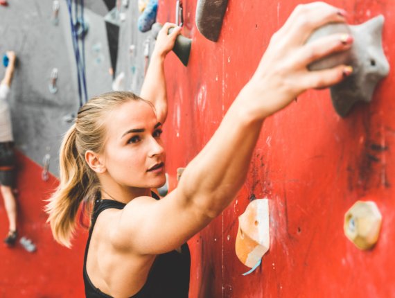 Mujer escalando en una pared de boulder