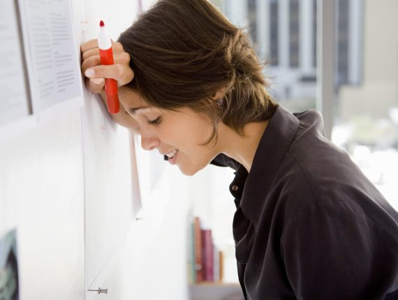 A woman in search of the right remedies for stress leans desperately against the wall