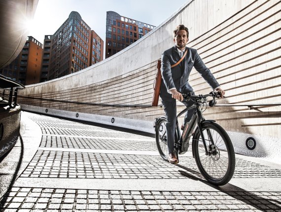 Mann im Anzug fährt auf einem E-Bikes