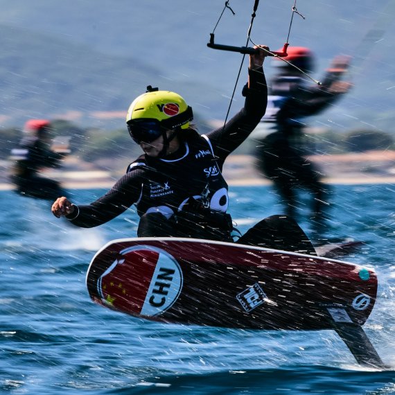 Eine Formula Kite Pilotin fliegt übers Wasser 