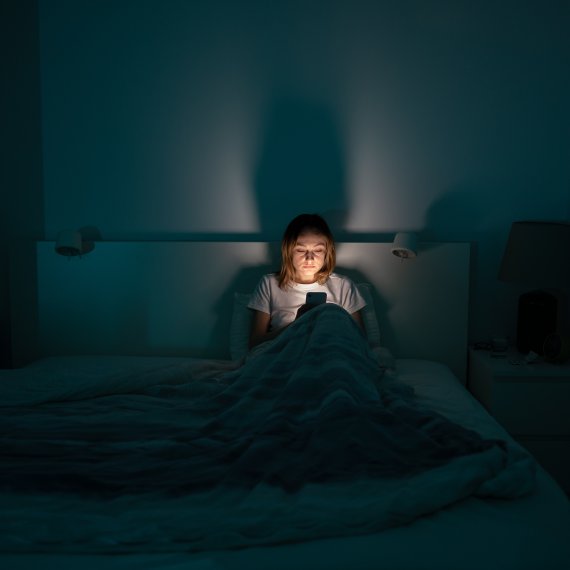 Frau nachts im Bett am Handy
