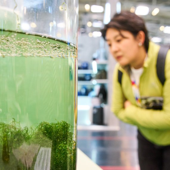 Person auf der ISPO 2024 schaut sich nachhaltige Biomaterialien an