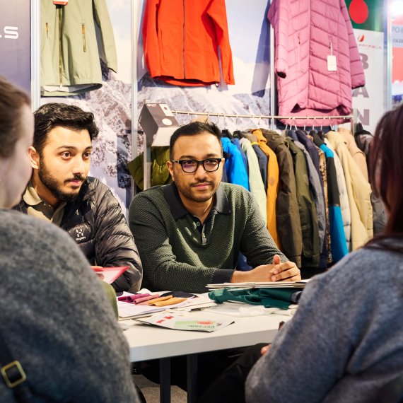 Two retailers and two interested customers discuss outdoor topics at ISPO 2024