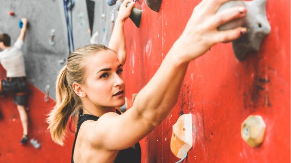 Mujer escalando en una pared de boulder