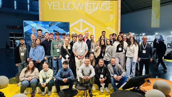 A group picture of the Young Talents in front of the Yellow Stage at ISPO Munich