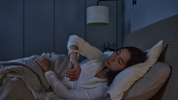 Frau trackt ihren Schlaf im Bett