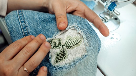 Jeans with a hole are sewn with patches