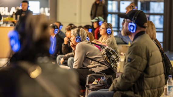 Sitzende Personen mit Kopfhörer bei einem Talk auf der ISPO 2024
