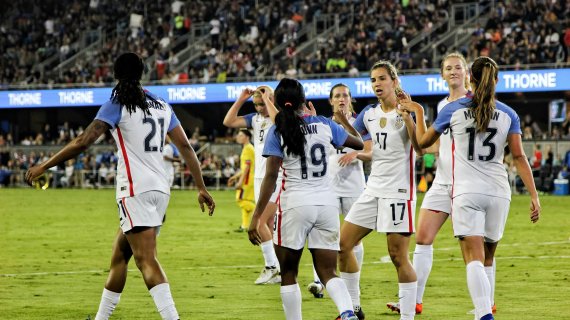 Women play soccer in the stadium and high-five each other