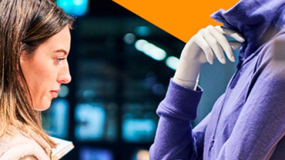 Besucherin betrachtet Jacke in der Award Exhibition Area der ISPO