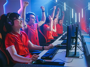 Mehrere jubelnde eSports Akteure vor ihren Bildschirmen